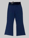Navy blue pants on a tiled floor with a tag attached.