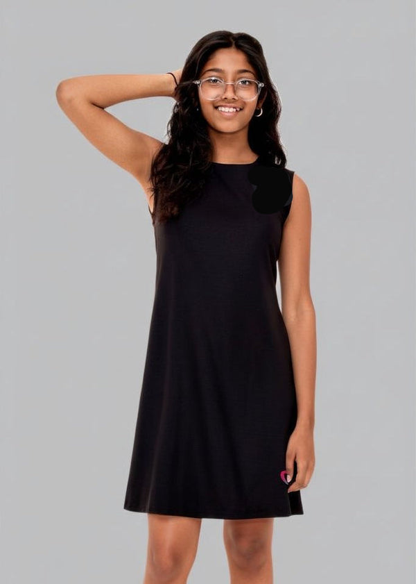 teen girl wearing a black dress against a gray background